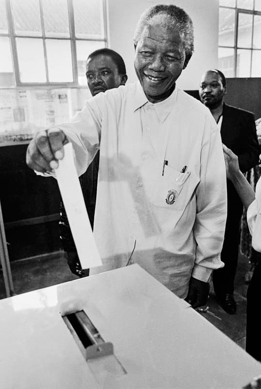 Nelson Mandela smiling as he casts his vote in South Africa's 1994 election