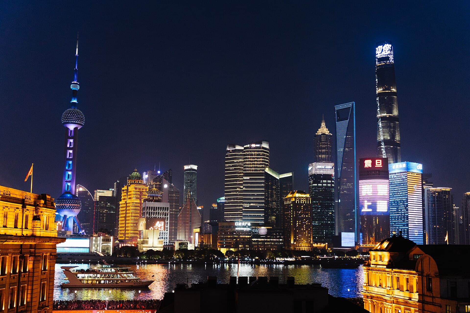 The illuminated skyscraper skyline of Pudong across the river from historic Shanghai